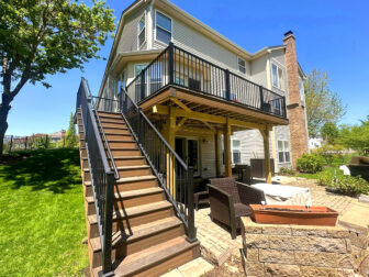 Multi-level deck with modern black railings and a shaded stone patio in Dunwoody, GA
